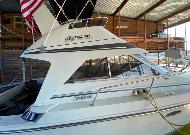Slide: The Image of 1984 Trojan 10 Meter Sedan boat docked under a covered marina. - 12