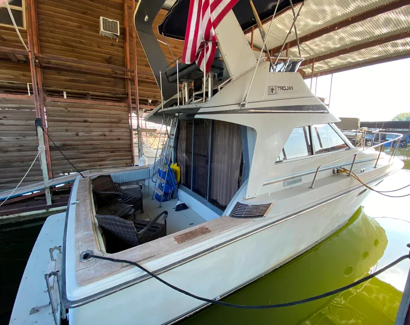 Slide: The Image of 1984 Trojan 10 Meter Sedan boat docked in a covered marina. - 13