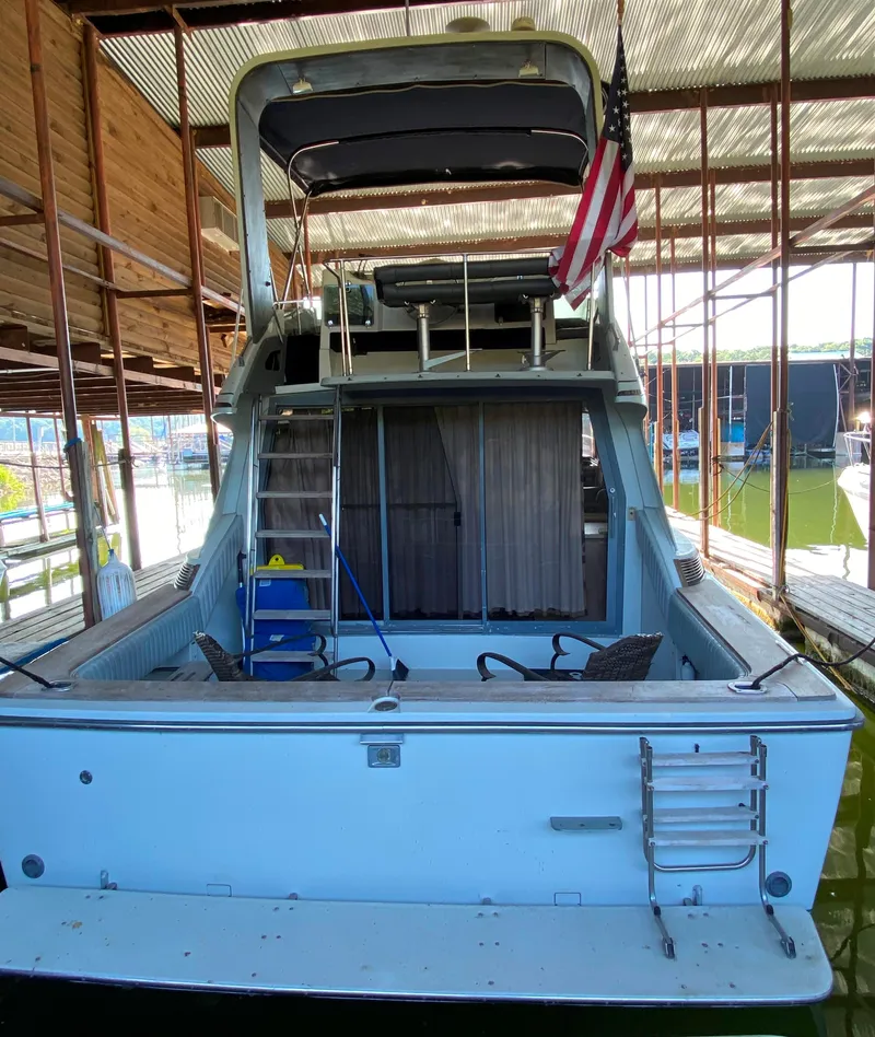 Slide: The Image of 1984 Trojan 10 Meter Sedan boat docked in a covered marina. - 14