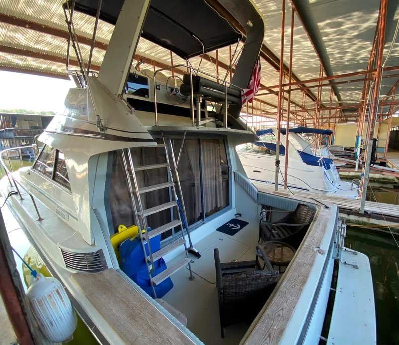 Slide: The Image of 1984 Trojan 10 Meter Sedan docked in a covered marina. - 15