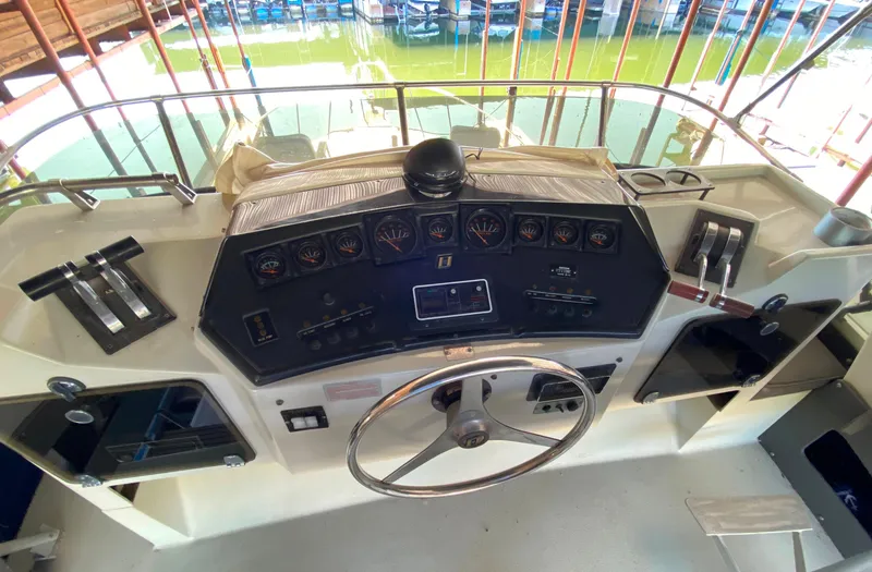 Slide: The Image of 1984 Trojan 10 Meter Sedan boat dashboard with steering wheel and control panel. - 16