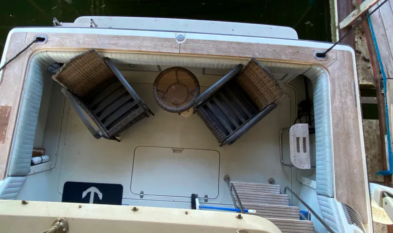 Slide: The Image of 1984 Trojan 10 Meter Sedan boat interior with wicker chairs and table. - 20