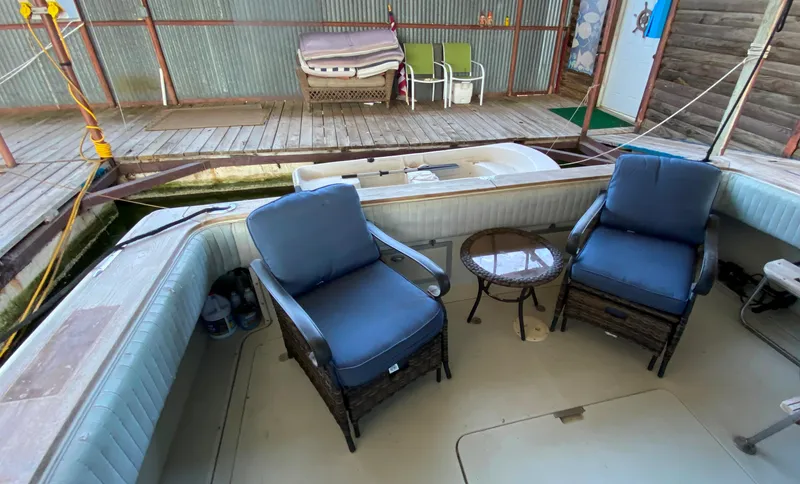Slide: The Image of 1984 Trojan 10 Meter Sedan boat with blue cushioned chairs on deck. - 21