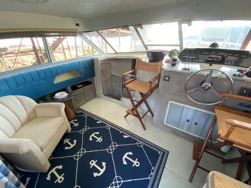 Slide: The Image of Interior of a 1984 Trojan 10 Meter Sedan boat with seating and nautical decor. - 23