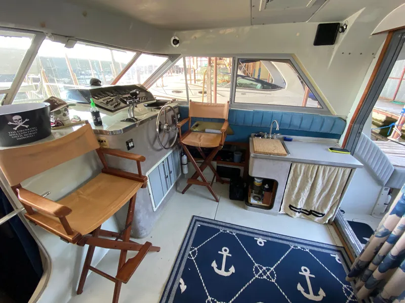 Slide: The Image of 1984 Trojan 10 Meter Sedan boat interior with helm, chairs, and nautical decor. - 24