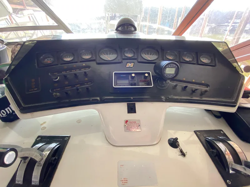 Slide: The Image of 1984 Trojan 10 Meter Sedan boat dashboard with gauges and controls. - 25