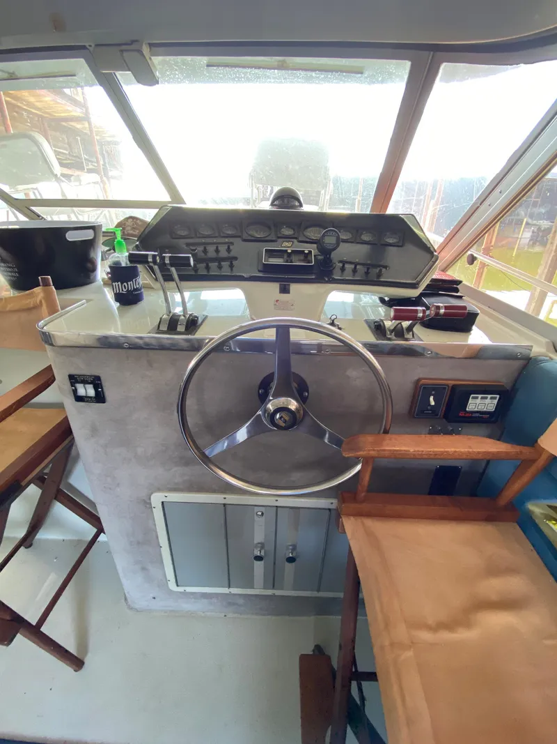 Slide: The Image of 1984 Trojan 10 Meter Sedan boat helm with steering wheel and control panel. - 26