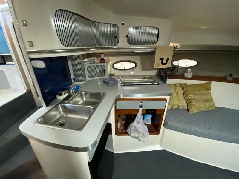 Slide: The Image of 1984 Trojan 10 Meter Sedan interior kitchen with sink, stove, and seating area. - 30