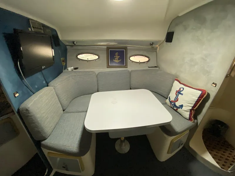 Slide: The Image of 1984 Trojan 10 Meter Sedan interior with cozy seating, table, and nautical decor. - 33