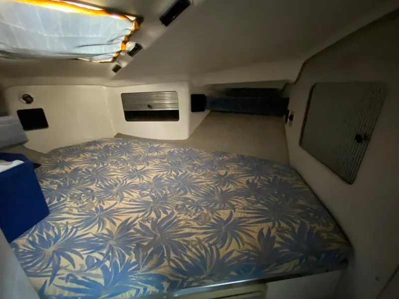 Slide: The Image of Interior cabin of a 1984 Trojan 10 Meter Sedan boat with floral-patterned bedding. - 34
