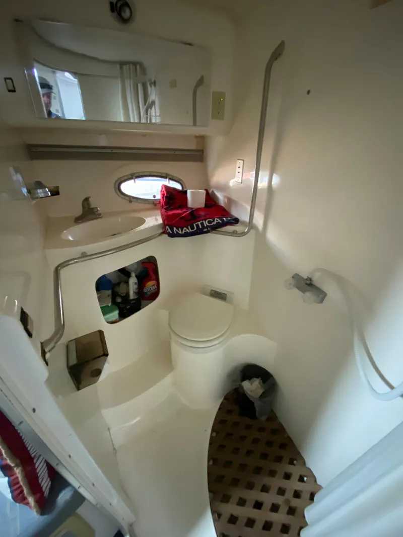Slide: The Image of 1984 Trojan 10 Meter Sedan boat bathroom with sink, toilet, and shower. - 35