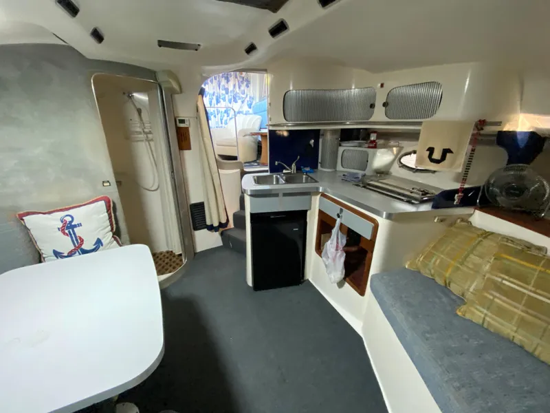 Slide: The Image of Interior of a 1984 Trojan 10 Meter Sedan boat with kitchen and seating area. - 37