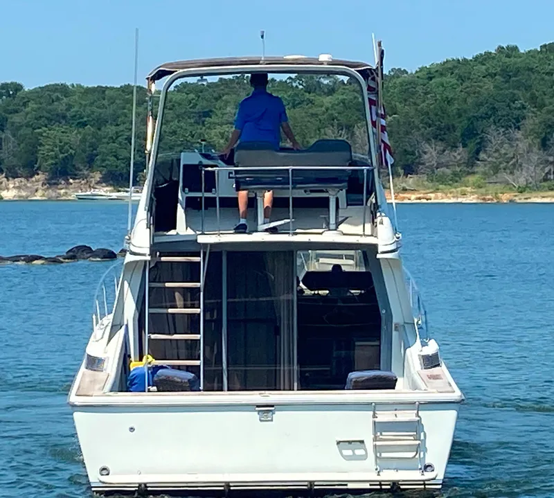 Slide: The Image of 1984 Trojan 10 Meter Sedan boat on a lake with a person at the helm. - 4