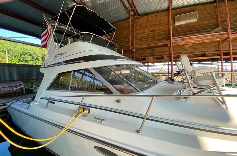 Slide: The Image of 1984 Trojan 10 Meter Sedan boat docked in a covered marina. - 11