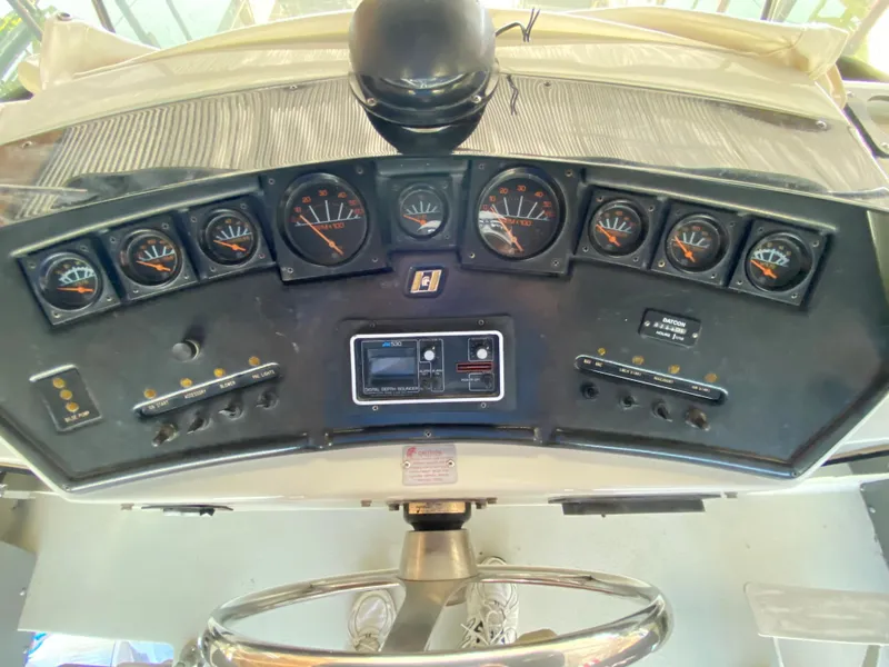 Slide: The Image of 1984 Trojan 10 Meter Sedan boat dashboard with gauges and controls. - 18