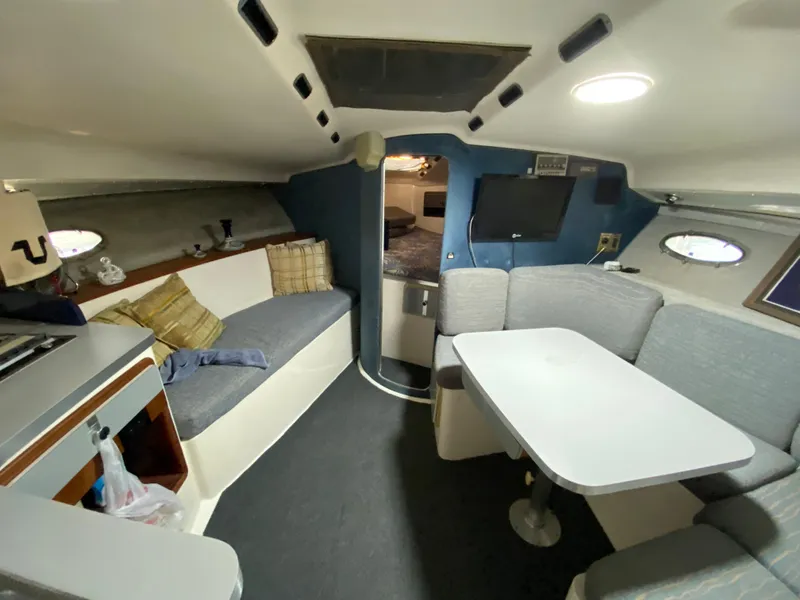 Slide: The Image of Interior of a 1984 Trojan 10 Meter Sedan boat with seating and dining area. - 29