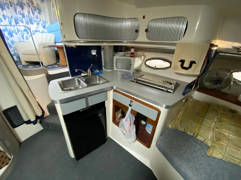Slide: The Image of 1984 Trojan 10 Meter Sedan boat interior with kitchenette and seating area. - 31