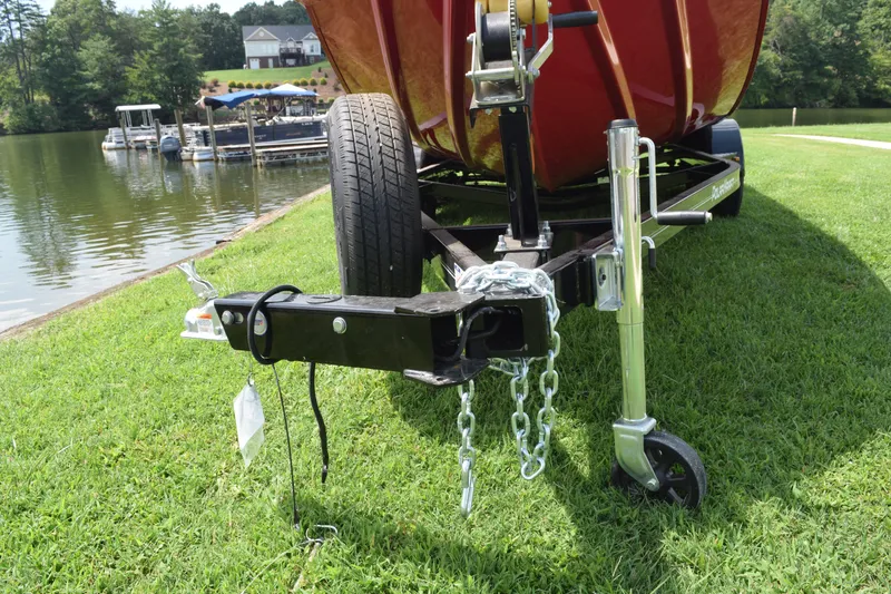 Slide: The Image of 2022 Polar Kraft Bass TX 195 Pro boat trailer hitch by a lake. - 7