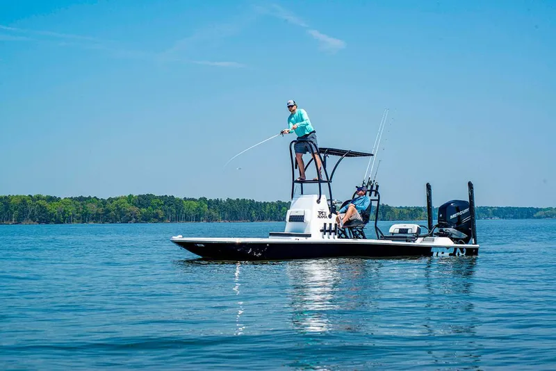 Slide: The Image of 2023 Tidewater 25 TPC Raptor boat on a lake with two people fishing. - 5