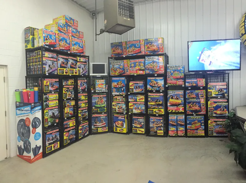 Slide: The Image of Fireworks display room with colorful boxes and a TV screen, showcasing various firework products. - 7