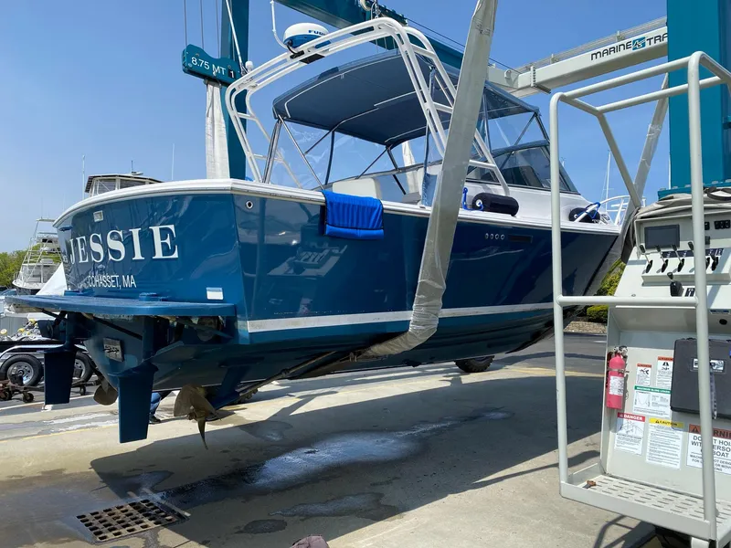 Slide: The Image of Blue 1995 Blackfin 29-2 Combi boat on lift, named "Jessie," in a marina setting. - 4