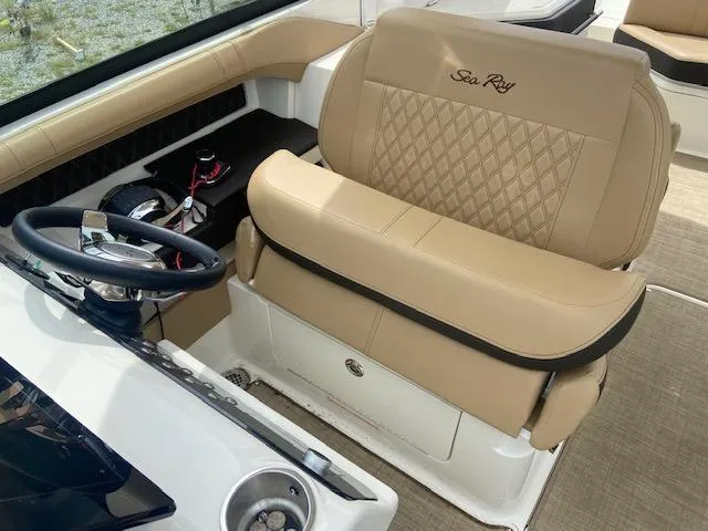 Slide: The Image of 2021 Sea Ray 310 SLX boat interior with tan leather seating and steering wheel. - 13