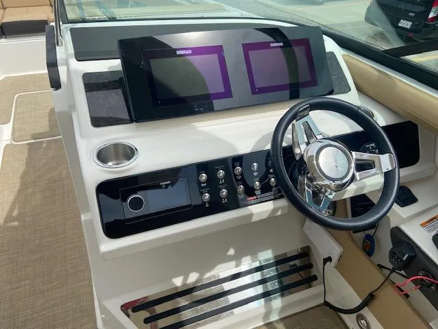 Slide: The Image of 2021 Sea Ray 310 SLX boat dashboard with dual Simrad displays and steering wheel. - 17