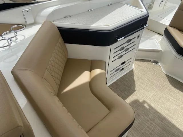 Slide: The Image of 2021 Sea Ray 310 SLX boat interior with tan seating and storage compartments. - 18