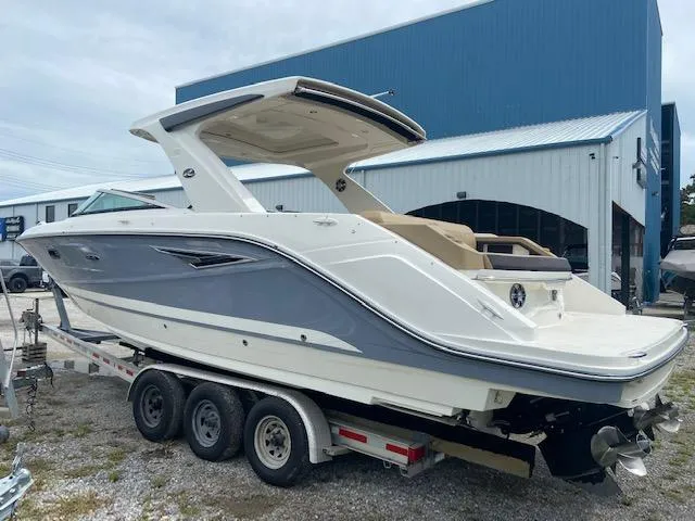 Slide: The Image of 2021 Sea Ray 310 SLX boat on a trailer outside a blue building. - 6