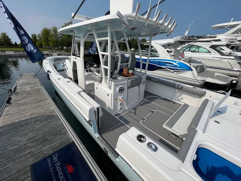 Slide: The Image of 2023 Everglades 365 CC boat docked at a marina, showcasing its sleek design. - 2