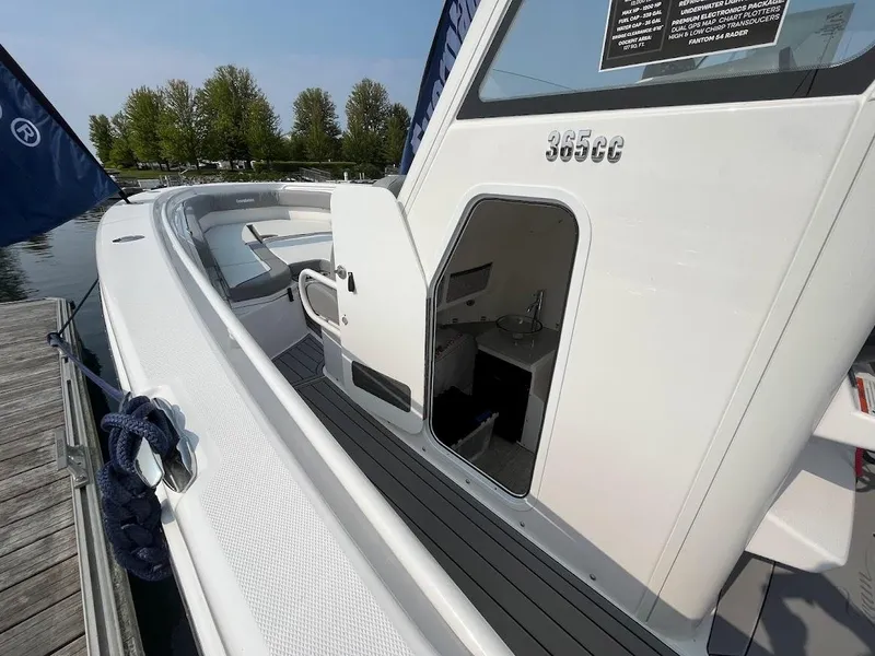 Slide: The Image of 2023 Everglades 365 CC boat docked, showcasing open cabin door and sleek design. - 4