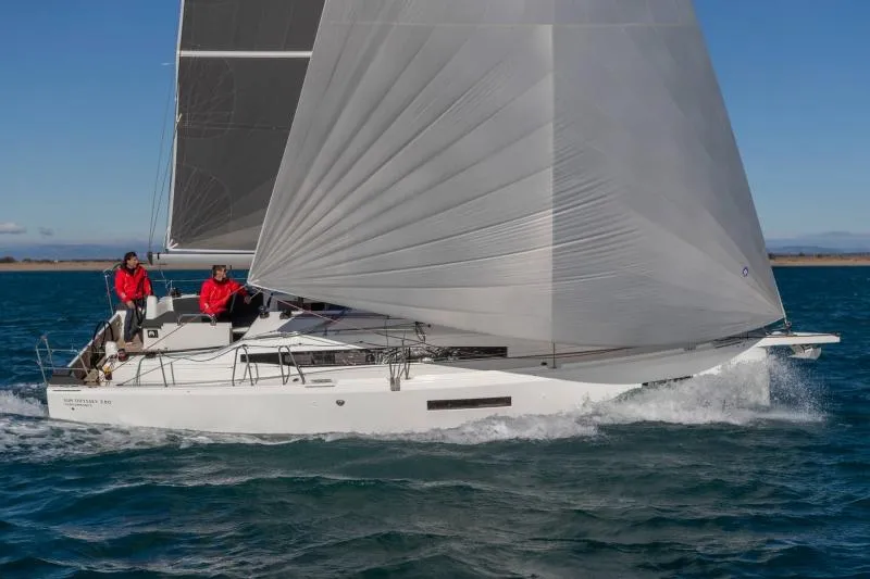 Slide: The Image of 2024 Jeanneau Sun Odyssey 380 sailing on open water with crew in red jackets. - 2