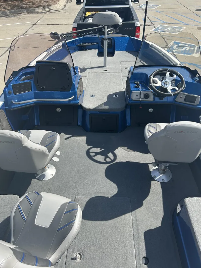 Slide: The Image of 2023 Nitro ZV20 boat interior with steering wheel and seating, parked on a trailer. - 6