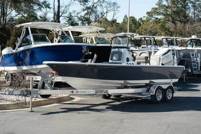 Slide: The Image of 2023 Sea Born FX22 Bay boat on trailer, parked near other boats. - 1