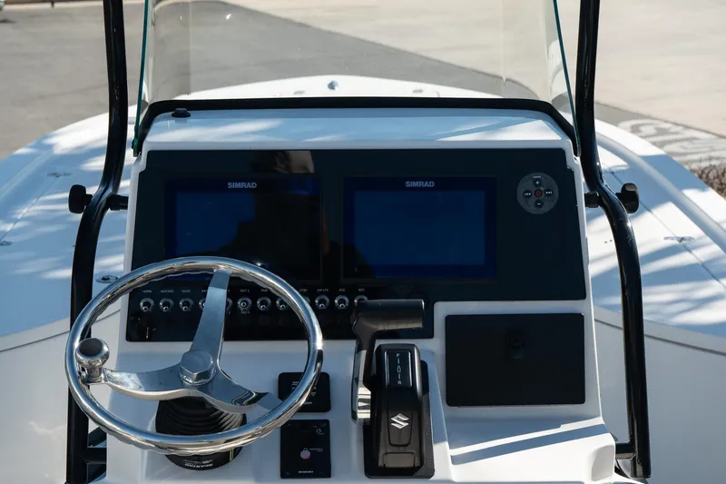 Slide: The Image of 2023 Sea Born FX22 Bay boat dashboard with steering wheel and navigation screens. - 11