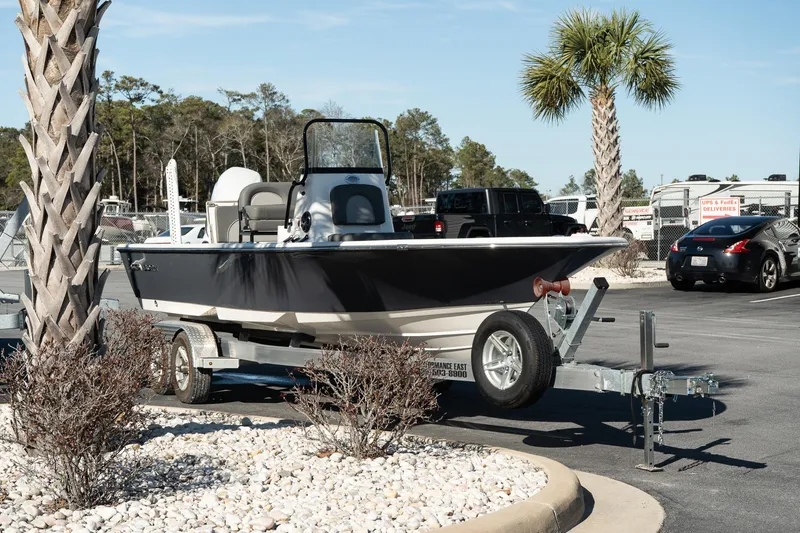 Slide: The Image of 2023 Sea Born FX22 Bay boat on trailer in parking lot, surrounded by palm trees. - 3
