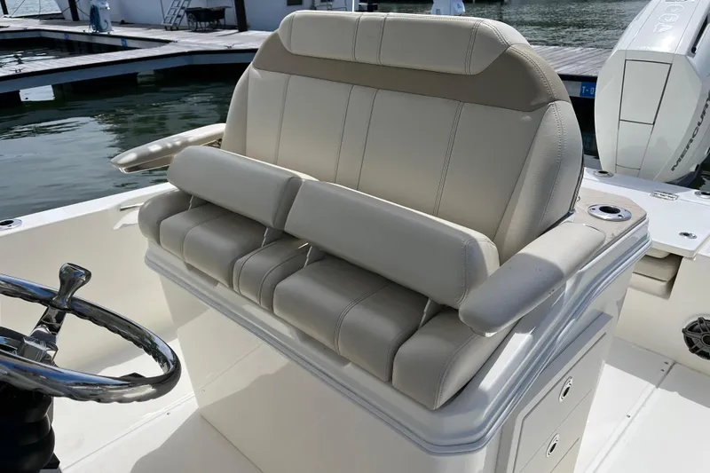 Slide: The Image of 2024 Boston Whaler 280 Dauntless helm seating with luxurious beige upholstery and steering wheel. - 11