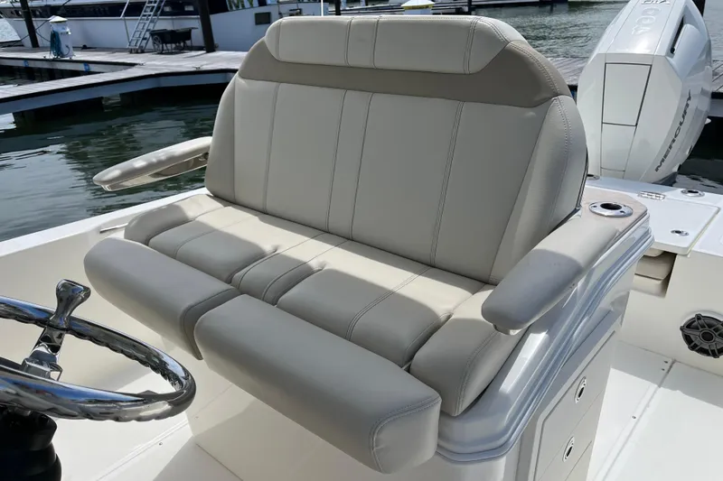 Slide: The Image of 2024 Boston Whaler 280 Dauntless boat seat with steering wheel, docked at marina. - 12