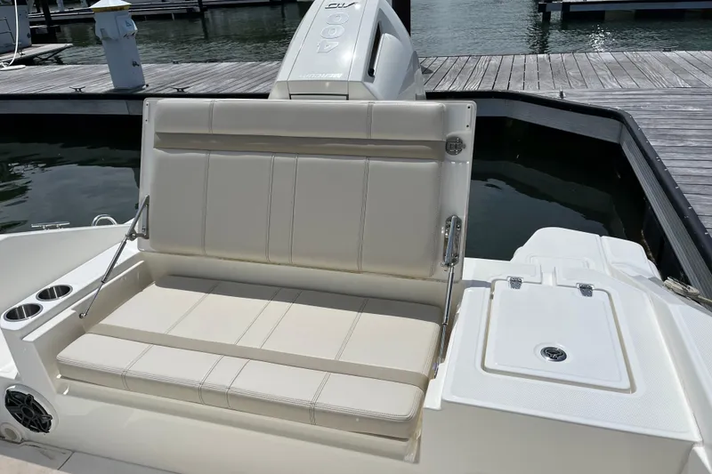 Slide: The Image of 2024 Boston Whaler 280 Dauntless boat seating area with cup holders and dock view. - 15