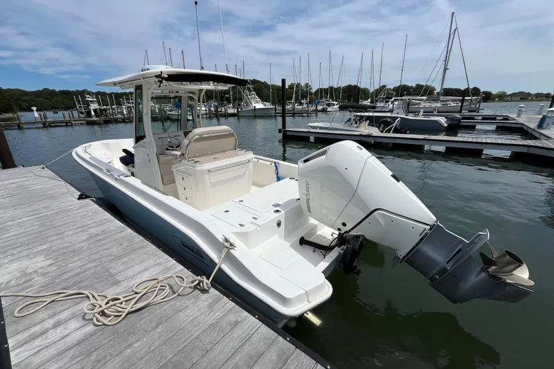 Slide: The Image of 2024 Boston Whaler 280 Dauntless docked at marina, showcasing sleek design and powerful engine. - 16