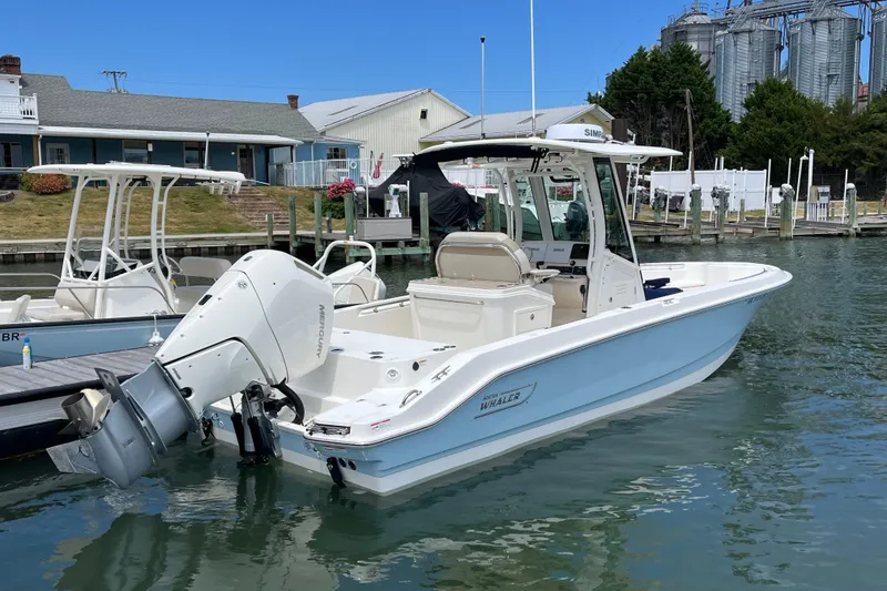 Slide: The Image of 2024 Boston Whaler 280 Dauntless boat docked in a marina, featuring a sleek design. - 18