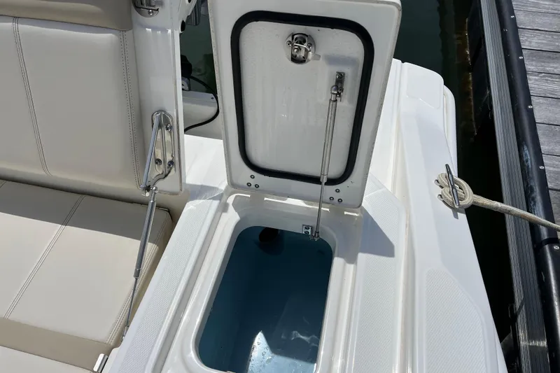 Slide: The Image of Open storage compartment on 2024 Boston Whaler 280 Dauntless boat, docked by water. - 19