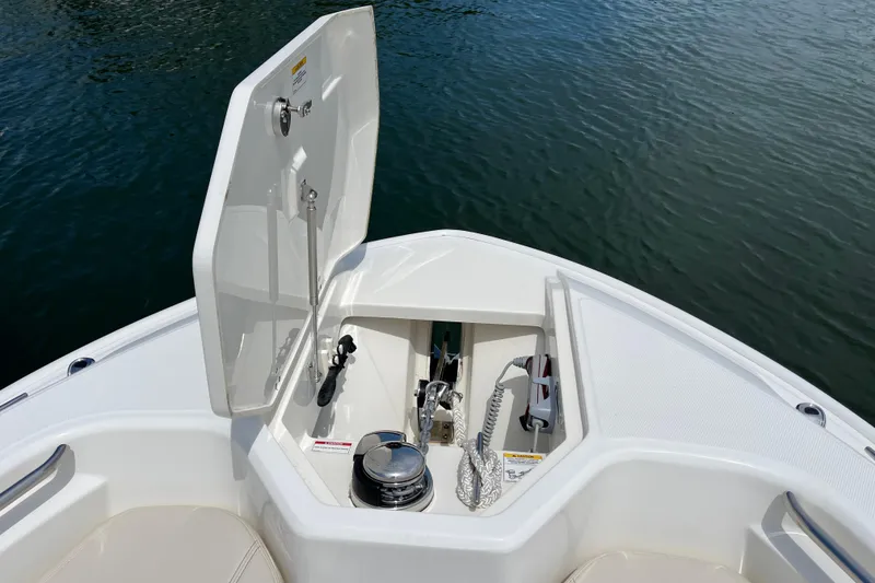 Slide: The Image of Open anchor compartment on 2024 Boston Whaler 280 Dauntless boat, showing marine equipment. - 6