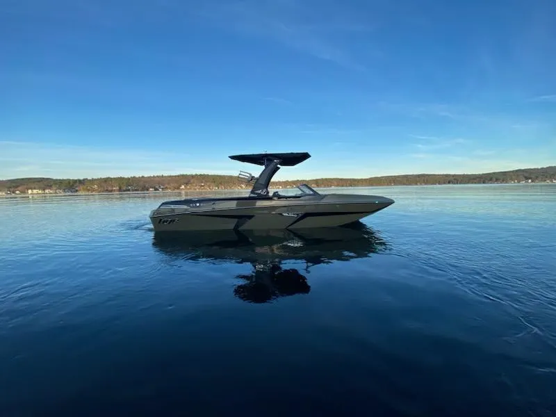 Slide: The Image of 2023 Tigé 24 RZX boat on calm lake under clear blue sky. - 2