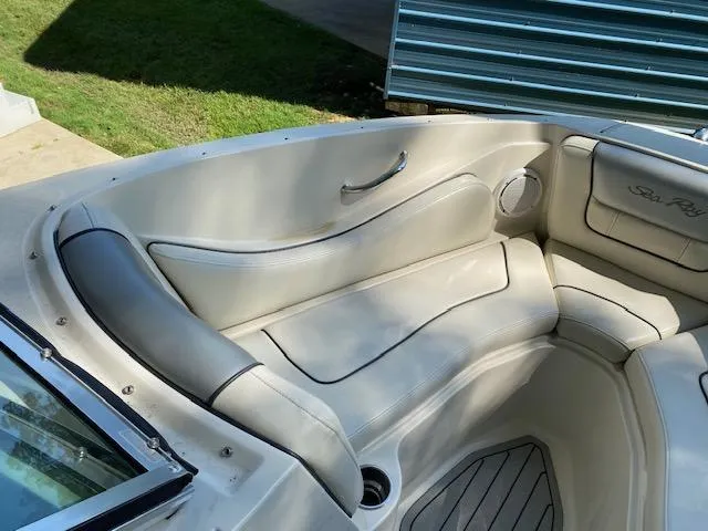 Slide: The Image of Interior seating of a 2010 Sea Ray 230 Select boat, featuring white cushioned seats. - 11