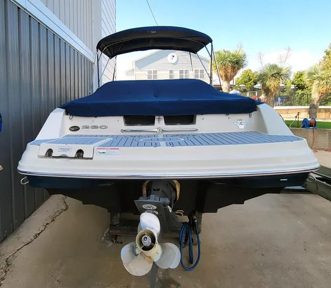 Slide: The Image of 2010 Sea Ray 230 Select boat, rear view, docked with blue cover. - 3
