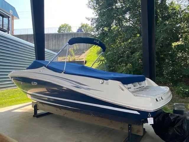 Slide: The Image of 2010 Sea Ray 230 Select boat with blue and white exterior, covered and docked. - 4