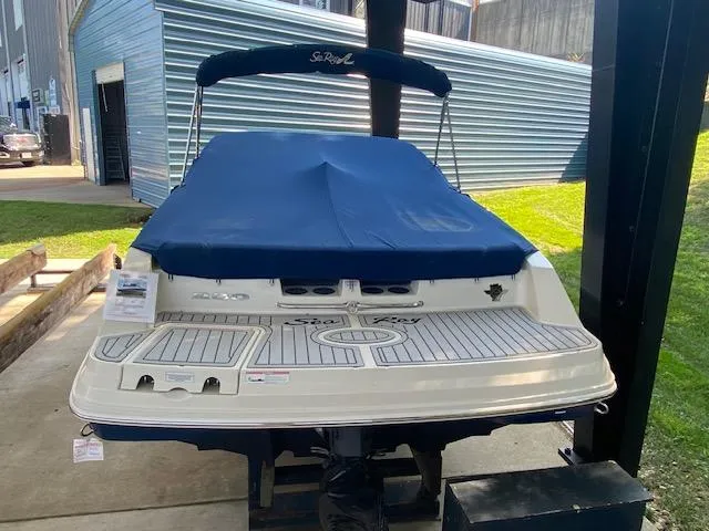 Slide: The Image of 2010 Sea Ray 230 Select boat with blue cover, docked in a marina. - 5