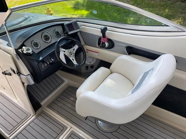 Slide: The Image of 2010 Sea Ray 230 Select boat cockpit with steering wheel and captain's chair. - 6