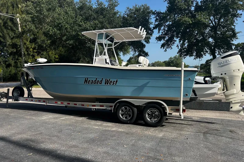 Slide: The Image of 1988 Hydra-Sports 2500 CC boat on trailer, named Headed West, with Suzuki outboard motor. - 14
